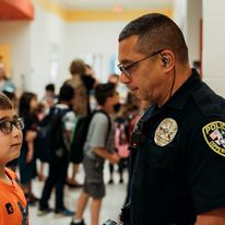 police officer talking with local child at a school